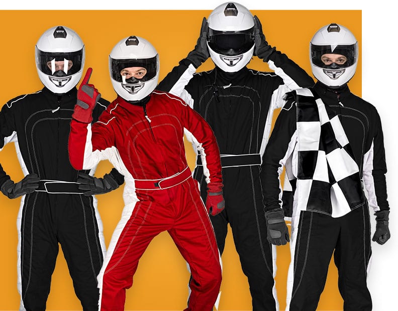 Four people in karting suits and white helmets stand against an orange background. Three wear black; one in red gestures with one finger up. Another holds a checkered flag. All have their faces covered.
