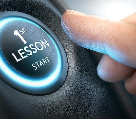 A close-up of a finger about to press a round, illuminated button labeled 1st LESSON START, resembling a car ignition button—perfect for Under 17 Young Drivers eager to begin their first lesson.